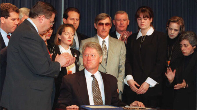 US President Bill Clinton (C-seated) looks up afte